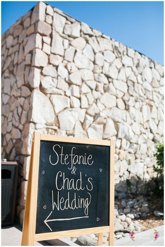  stefanie and chad’s wedding sign in front of a rock wall 