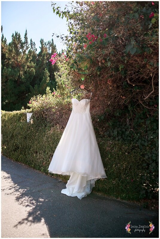  wedding dress hanging in the rose trim of the garden 