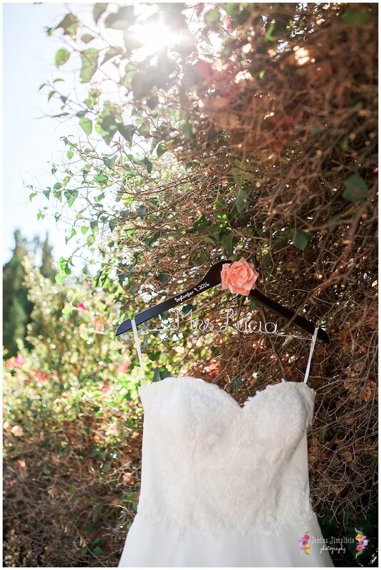  close up of wedding dress hanging on the rose trim of the garden 