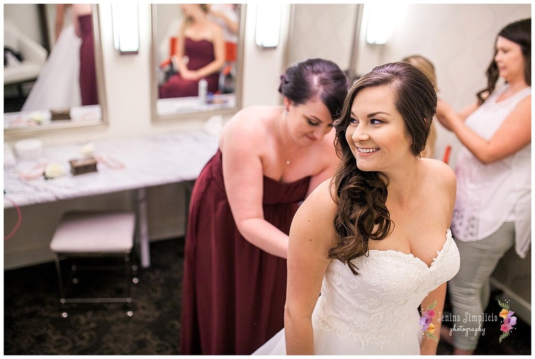  bride getting dressed with her bridesmaids 