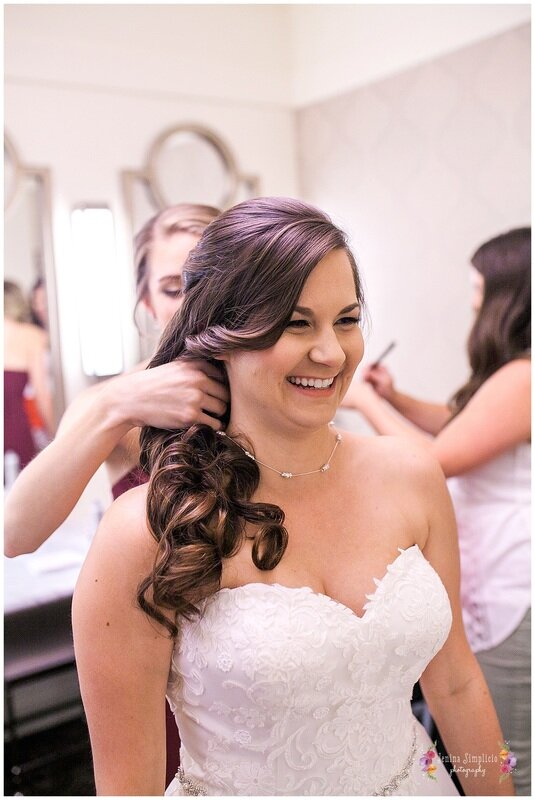  bride smiling as her necklace gets fastened  