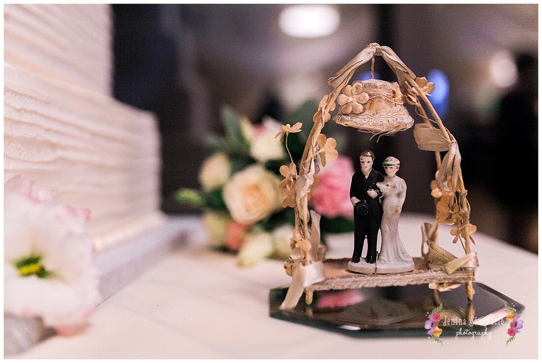  close up on wedding topper beside the cake 