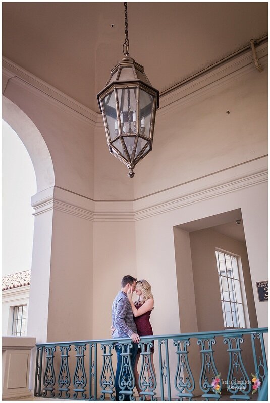  bride and groom on a balcony holding one another 
