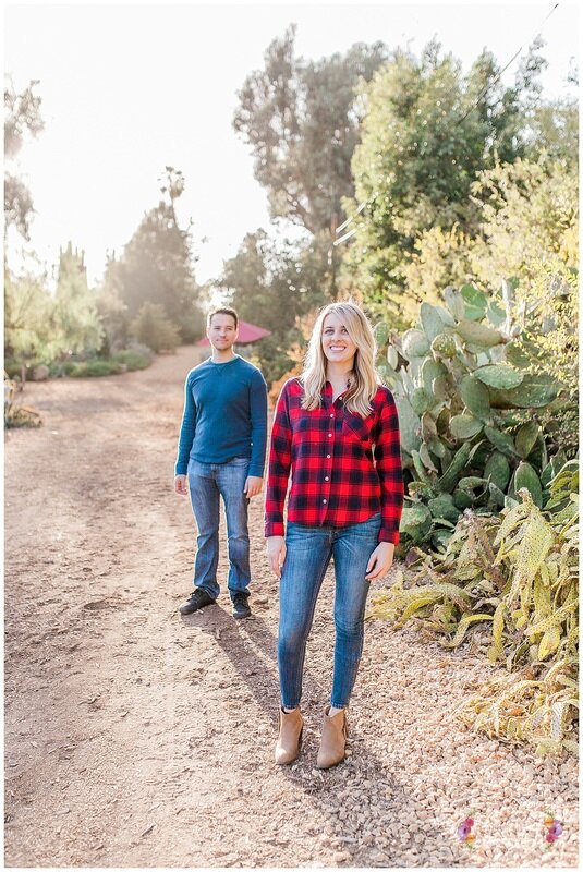  bride and groom standing in the dirt road with plants framing them 