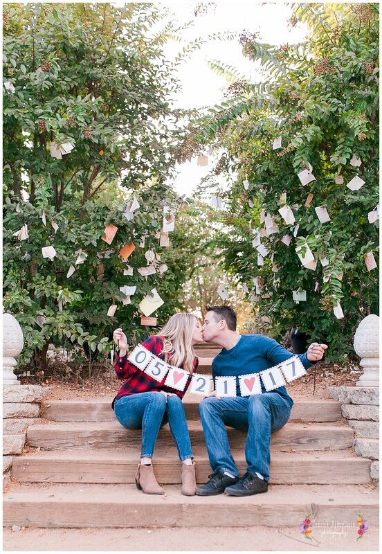  couple holding their wedding date banner 