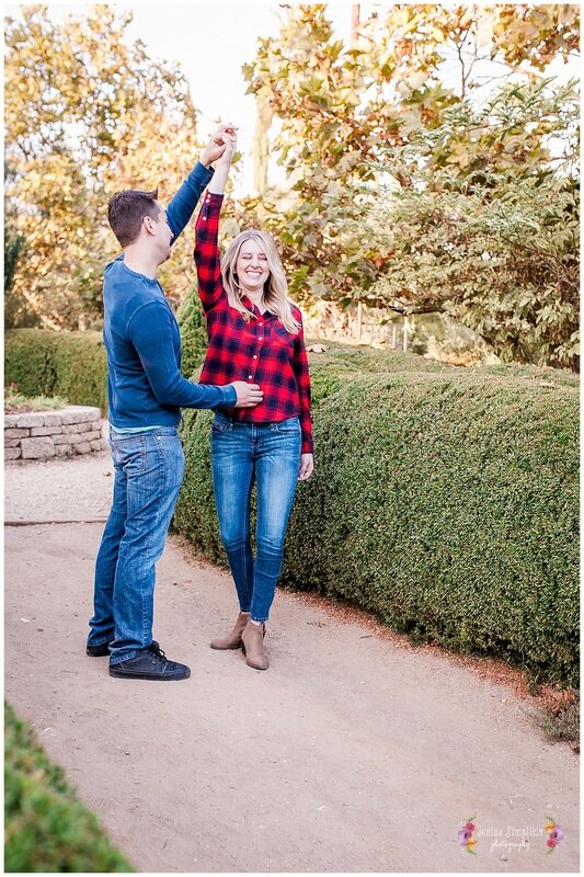  newly engaged couple twirling in the garden 