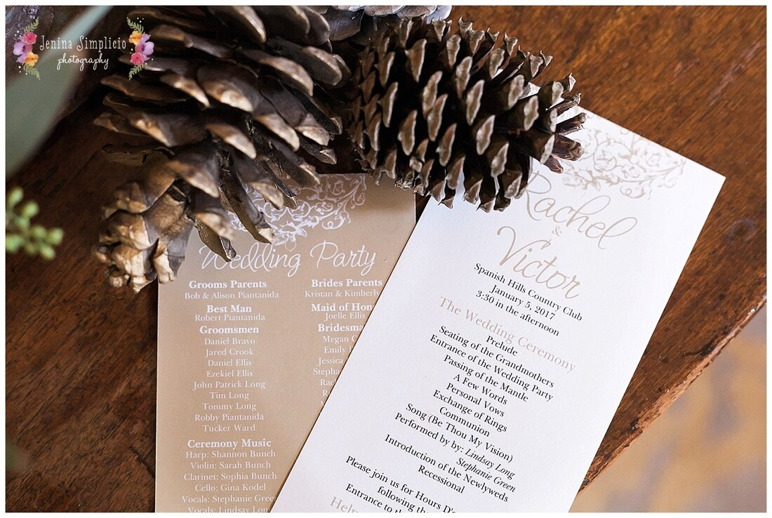  close up on wedding party invitations and pinecones 