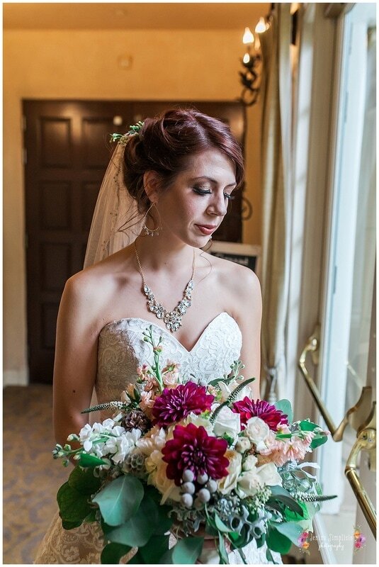  bride with her bouquet in the light of the window 