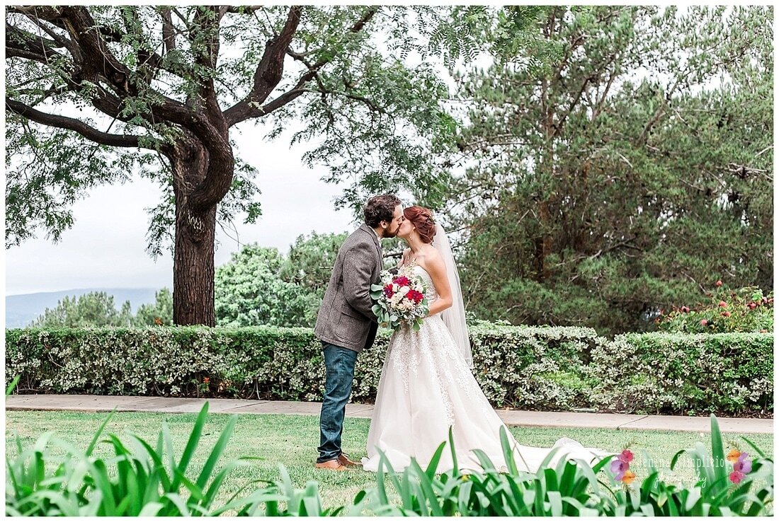  bride and groom kiss in the garden with trees 
