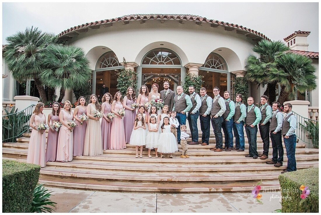  full wedding party standing on the steps of the ceremony building 