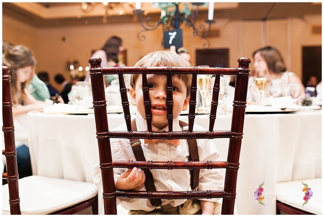  young boy sitting at the table looking through the chair 