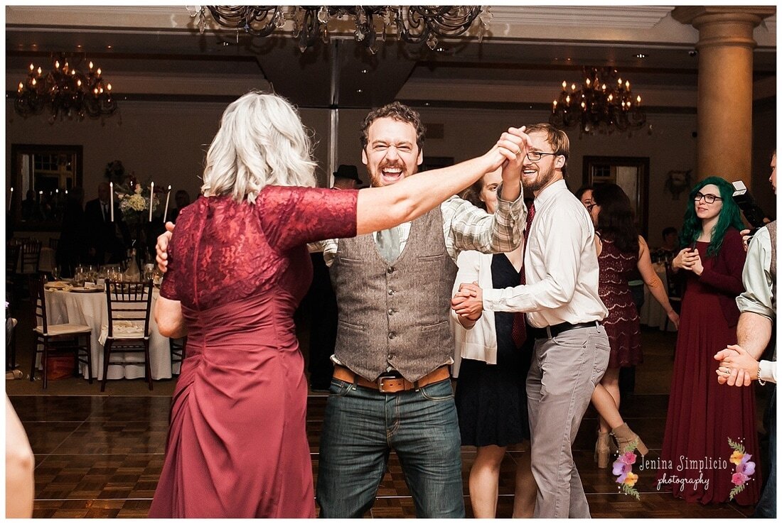  groom smiling as he dances around the dance floor  