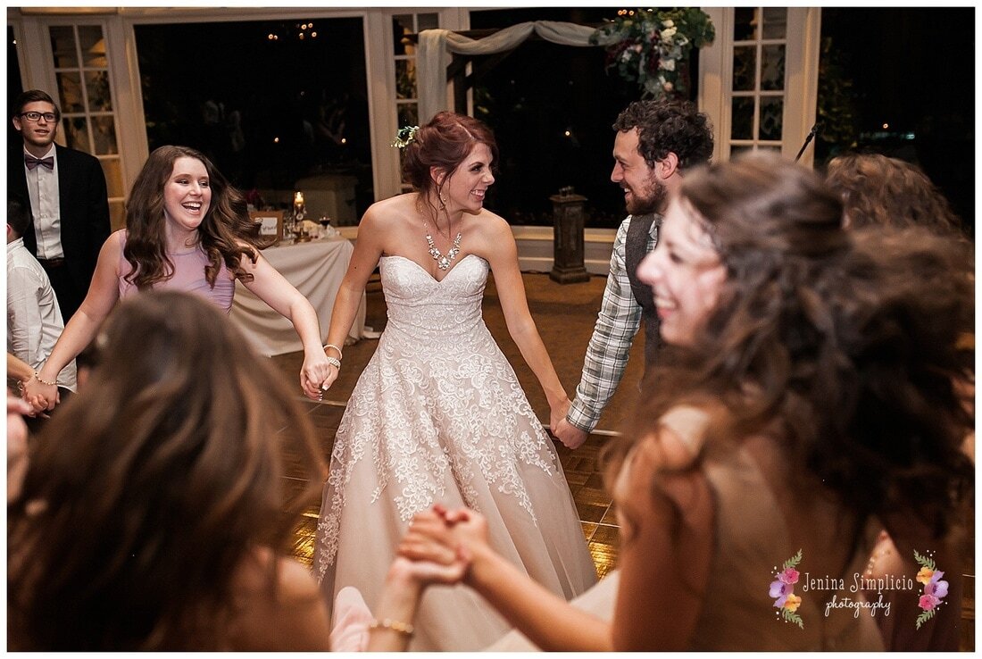  bride and groom alongside wedding guests dancing at the reception 