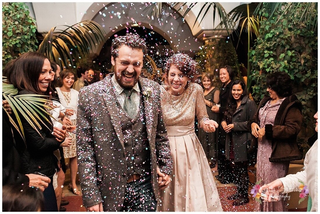  bride and groom covered in confetti as they join the guests for the reception 