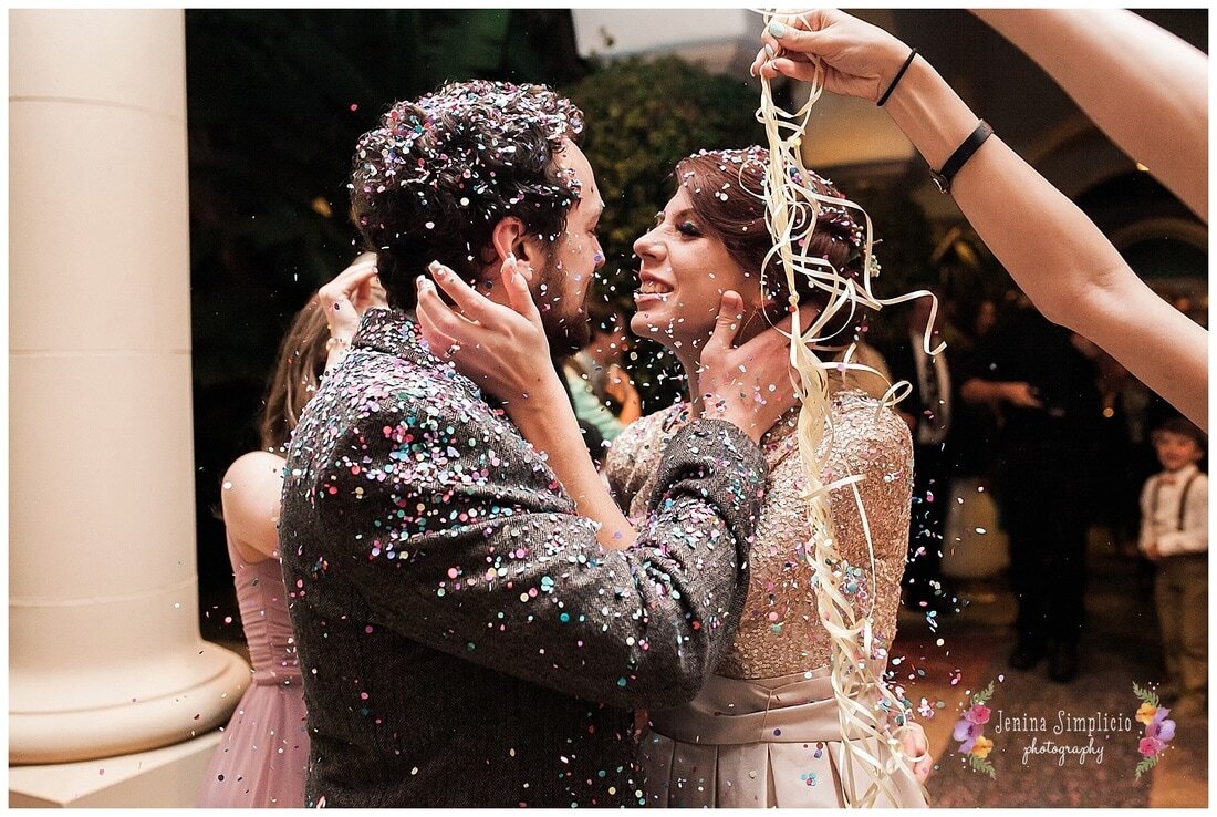  bride and groom kiss covered in confetti  