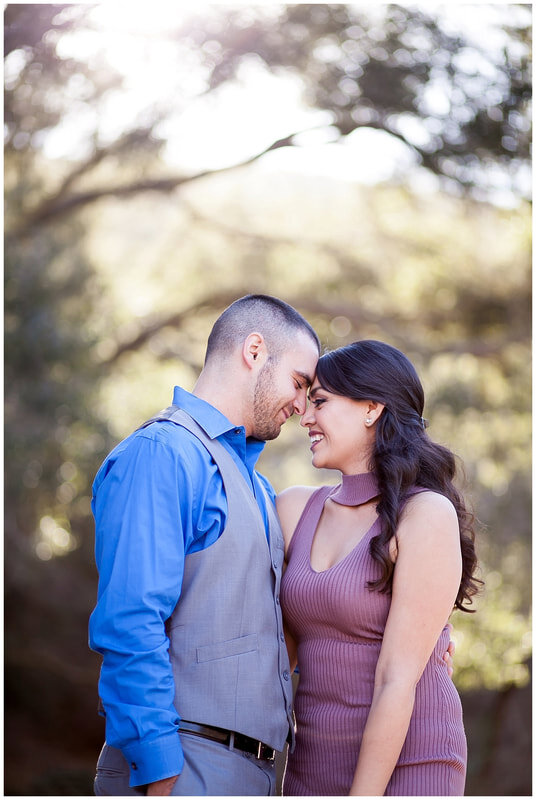  newly engaged couple touch foreheads in the woods 