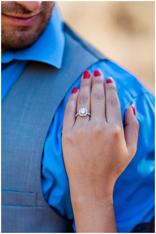  close up of engagement ring on grooms shoulder 