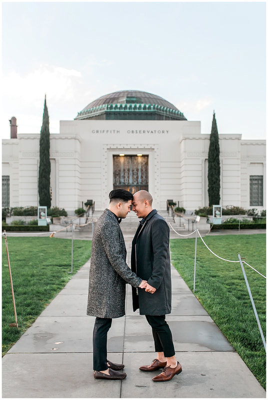  engaged couple touching foreheads in front of the griffith observatory 