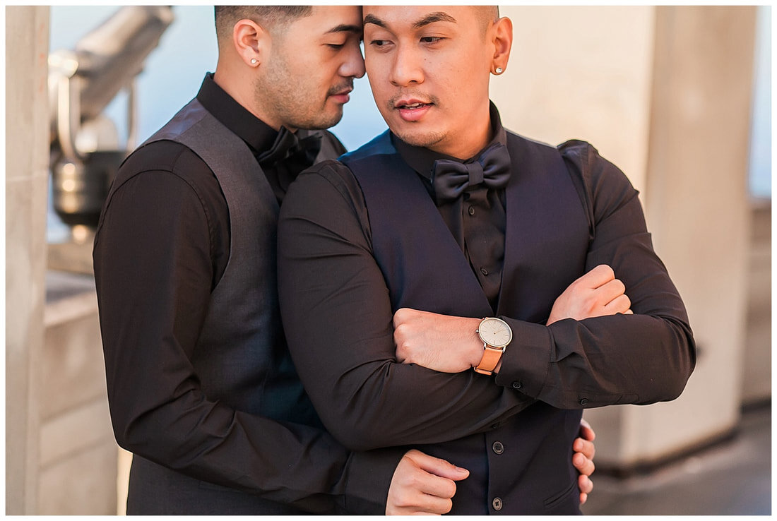  close up of grooms hands on his groom’s hips with his head against his 