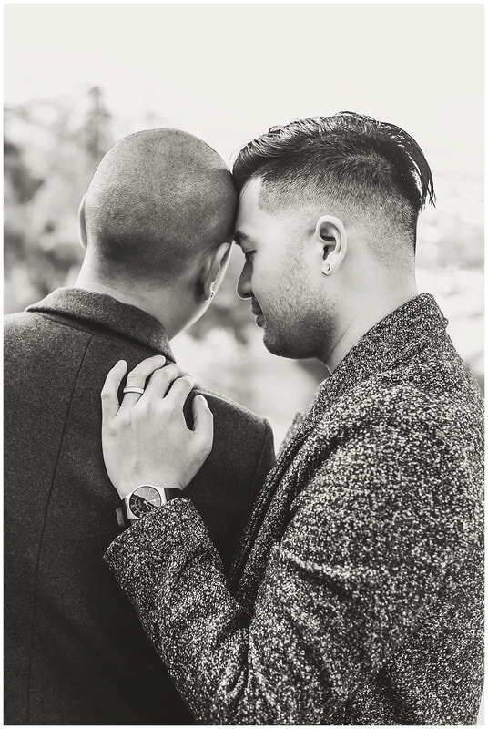  black and white photo of groom with his forehead against his groom and engagement ring on his finger 