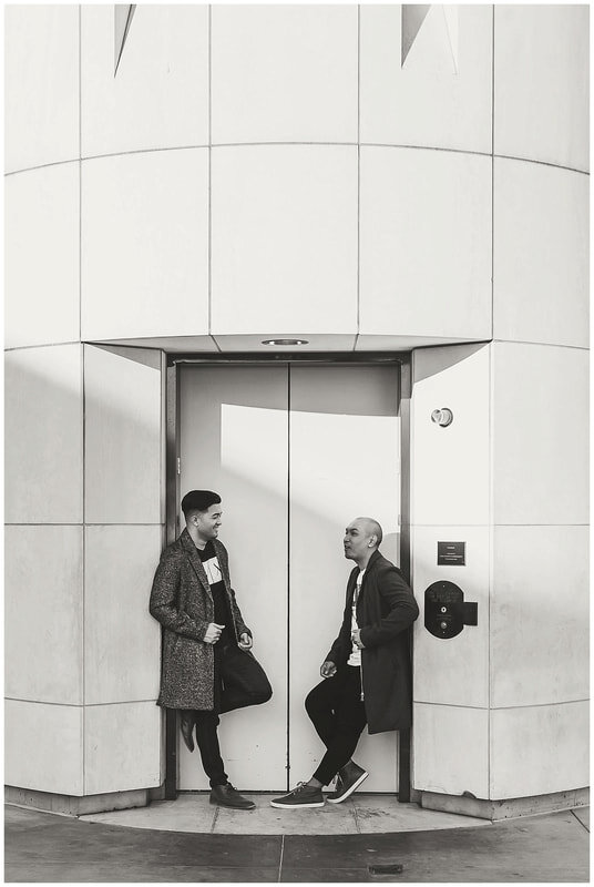  black and white photo of grooms standing in the elevator doorway 