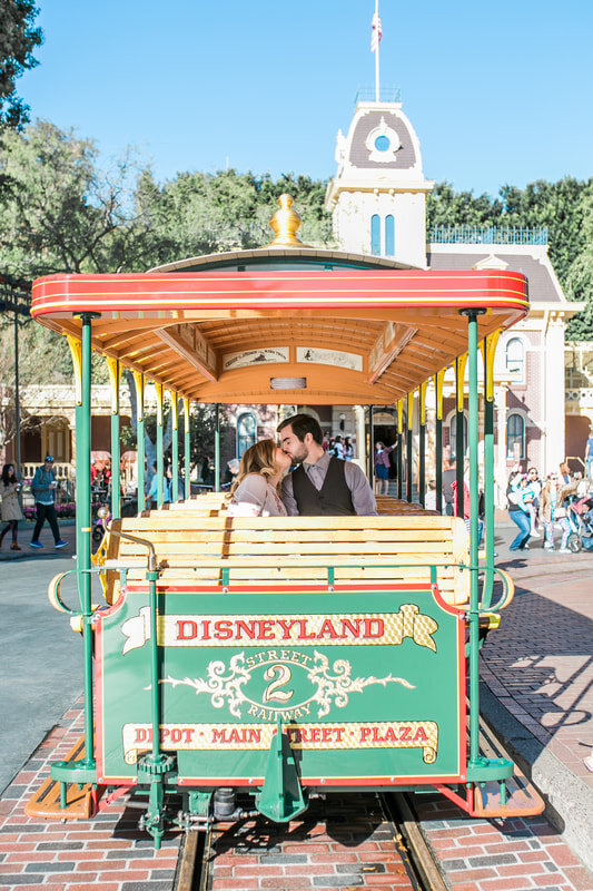  engaged couple kissing on the disneyland trolley  