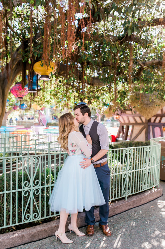  newly engaged couple kissing under lanterns by the teacups 