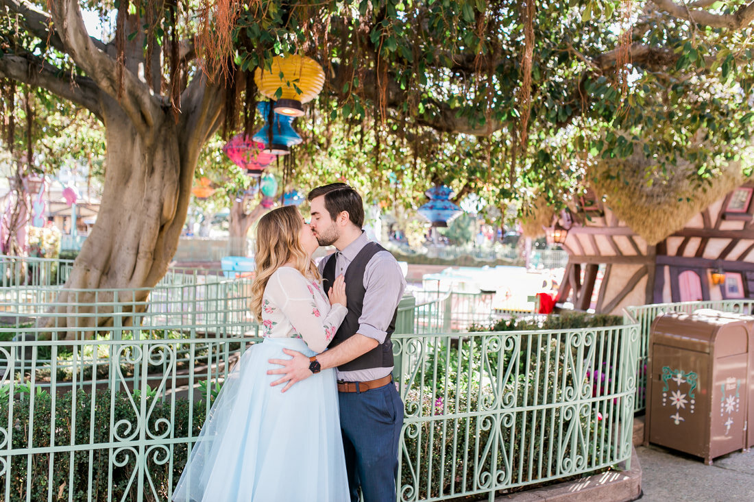  newly engaged couple kissing under lanterns by the teacups 