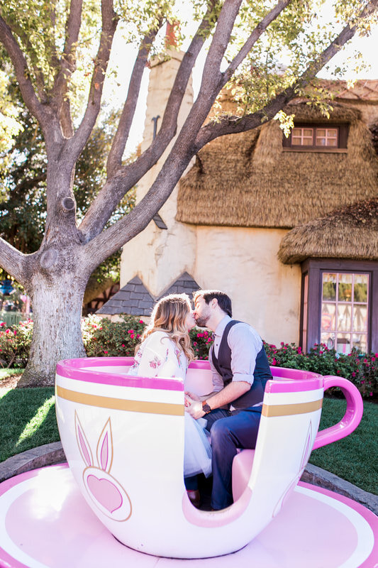  newly engaged couple kissing inside a pink teacup 
