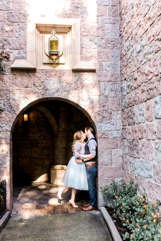  newly engaged couple kissing in a brick archway 