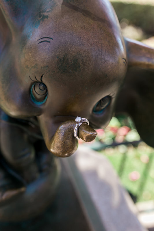  engagement ring sits on the trunk of a dumbo statue 