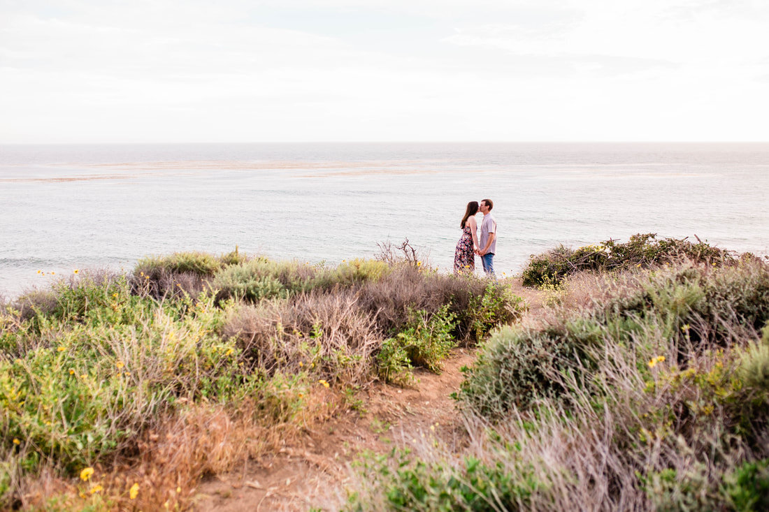  couple kissing near the ocean surrounded by the dunes 