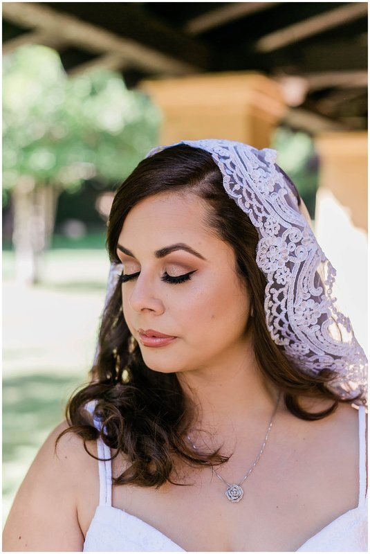  bride wearing a decorative veil and her eyes closed 