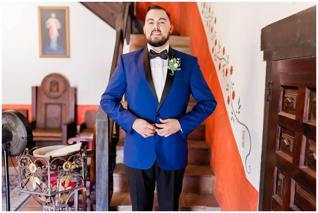  groom fastening his blue tux 