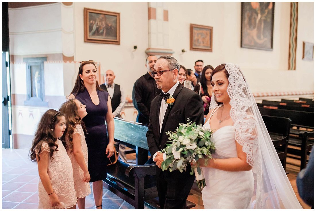  bride arrives at the aisle with her father and family watches her arrive 