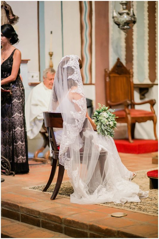  bride sitting at the front of the church holding her bouquet 