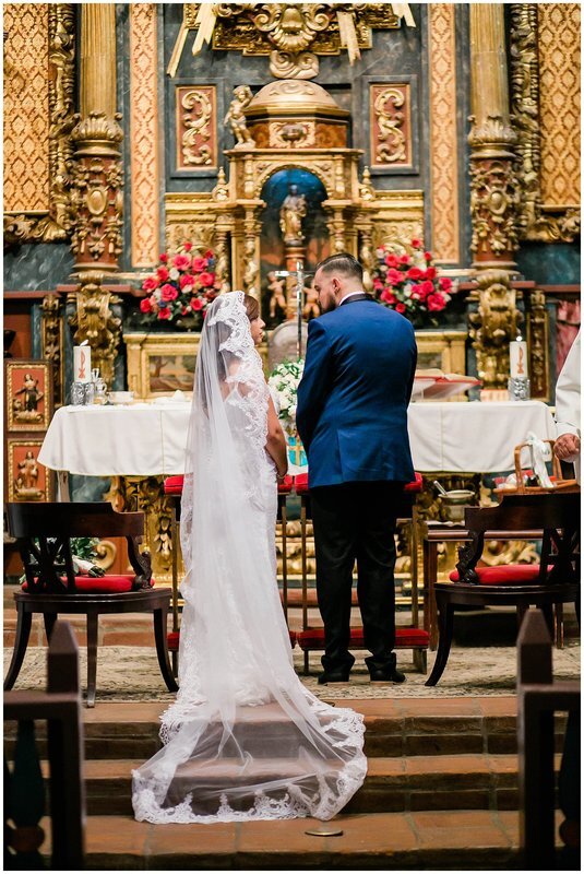  bride and groom look to one another at the church altar 