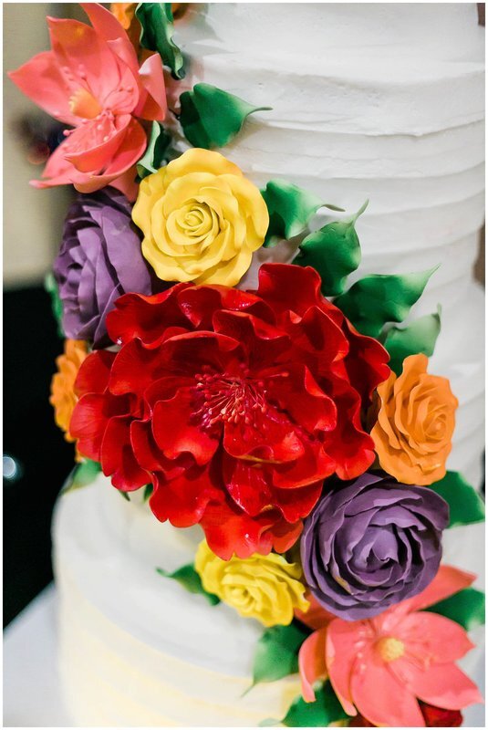  close up of colorful flowers on the wedding cake 