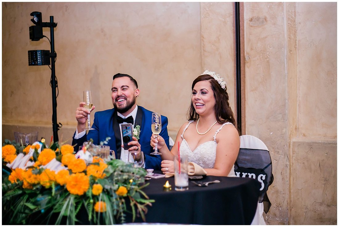  bride and groom sitting at the table toasting 