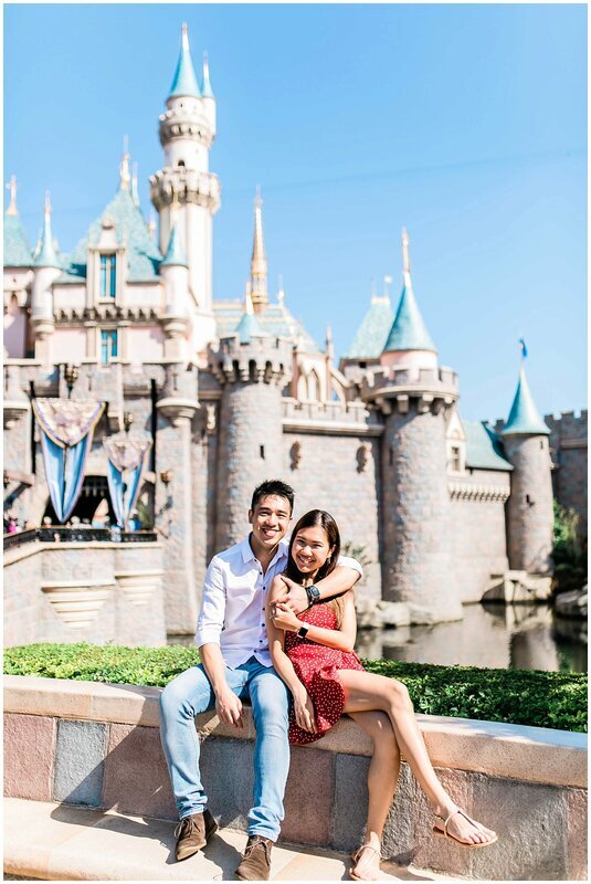  engaged couple in front of the magic kingdom 