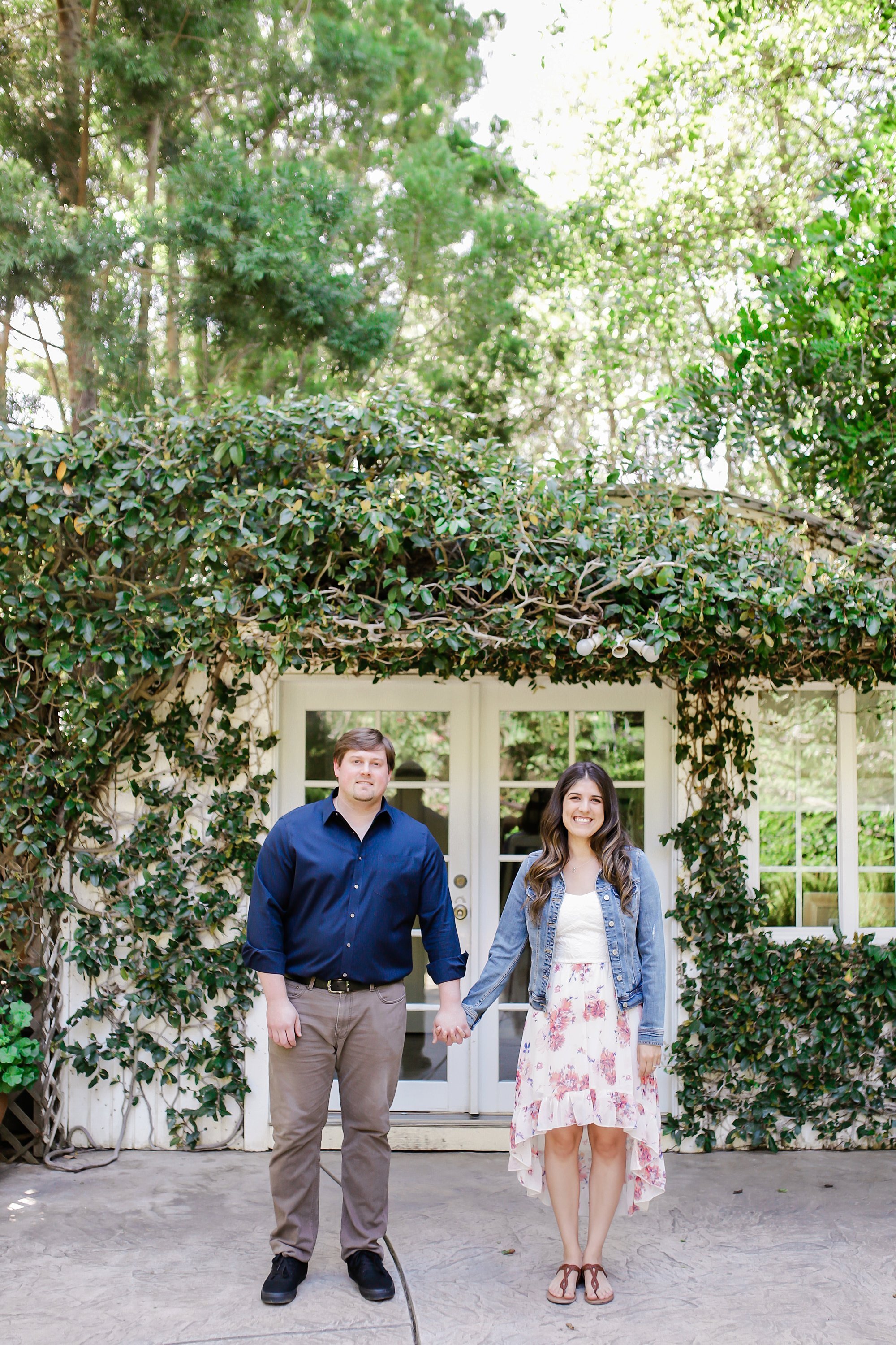  bride and groom standing in front of a door covered in ivy 