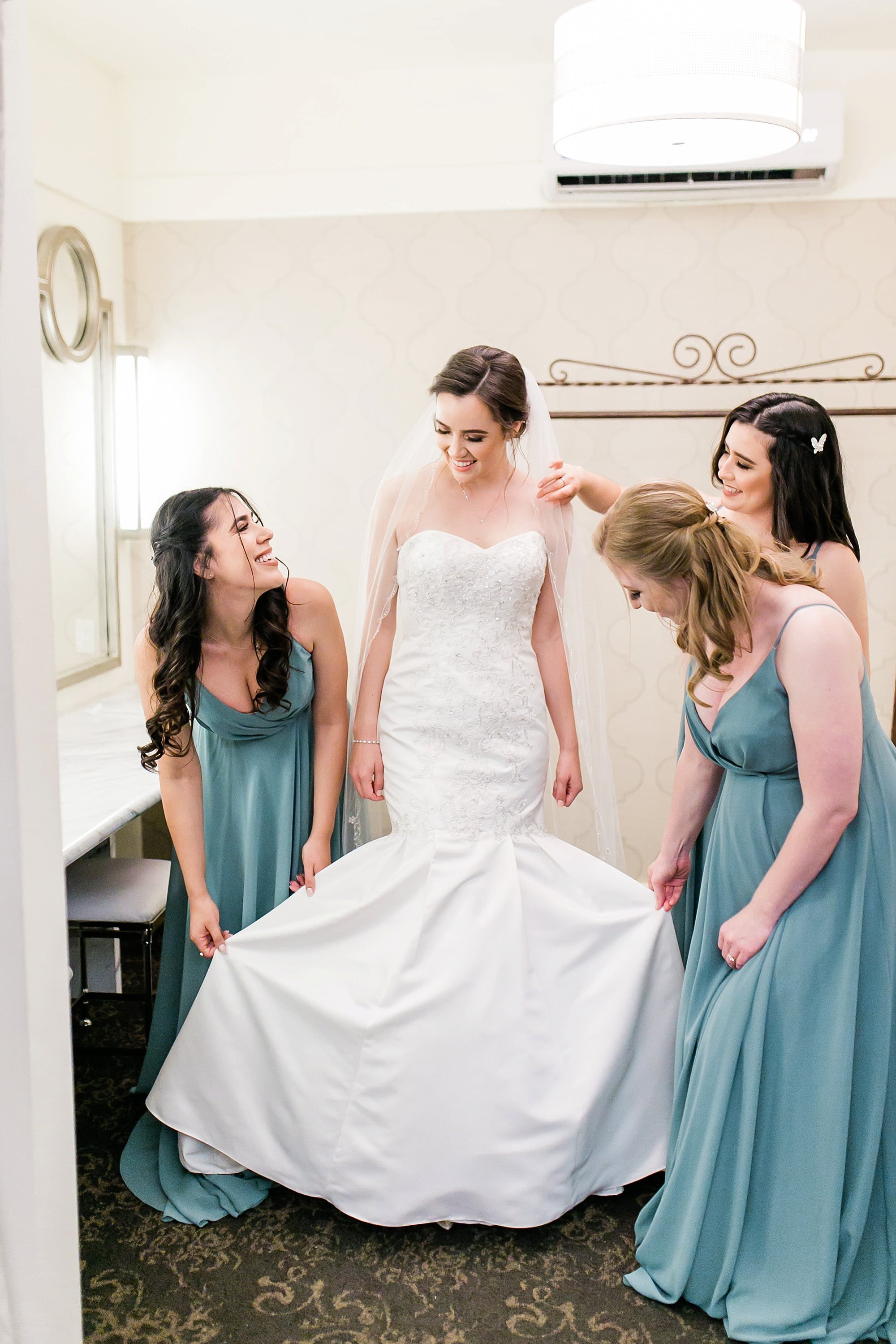  bridal party helping bride with her dress 