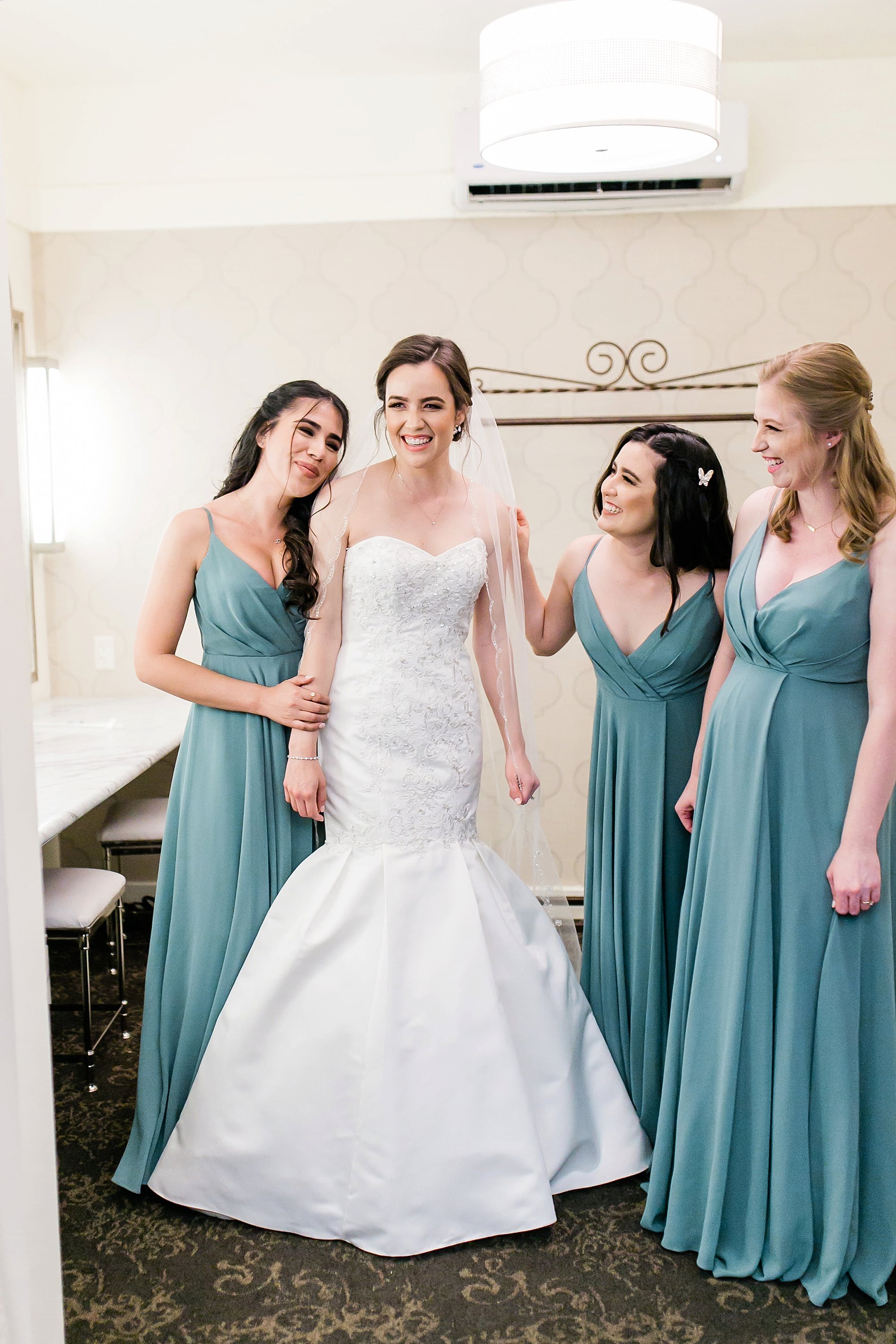  bridal party helping bride with her dress 