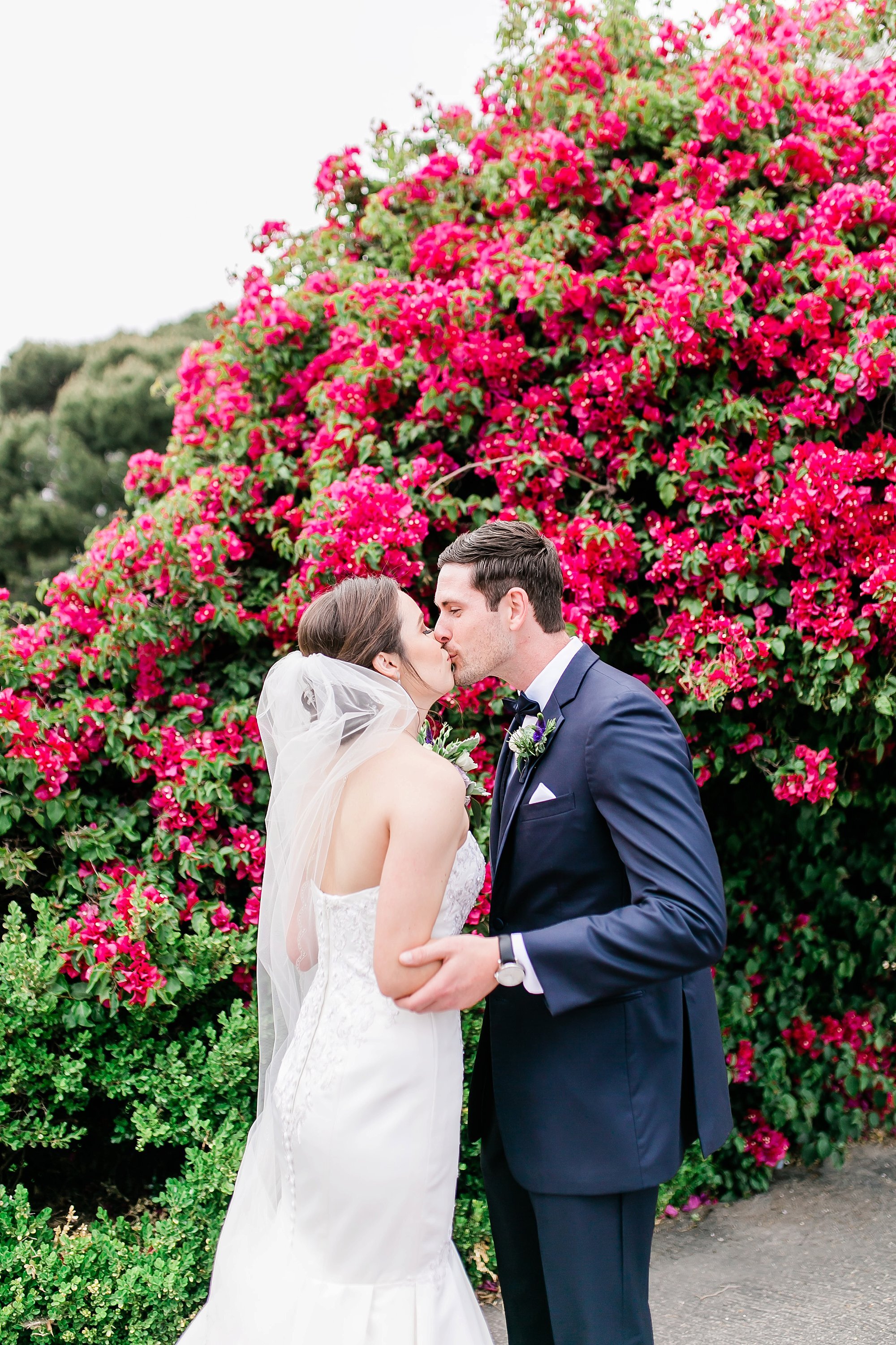  bride and groom in front of the pink flowers 