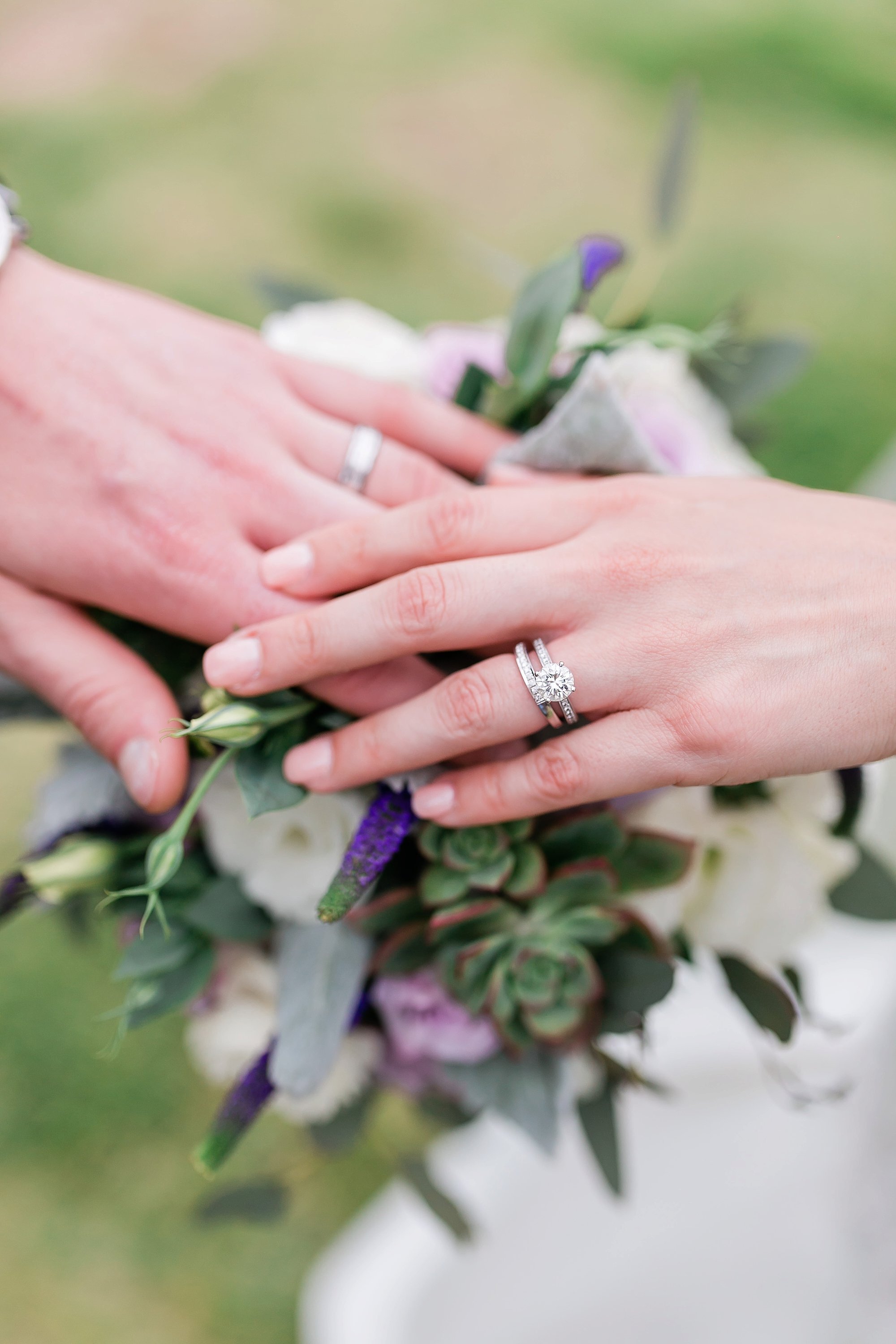  bride and groom’s hands with wedding bands 