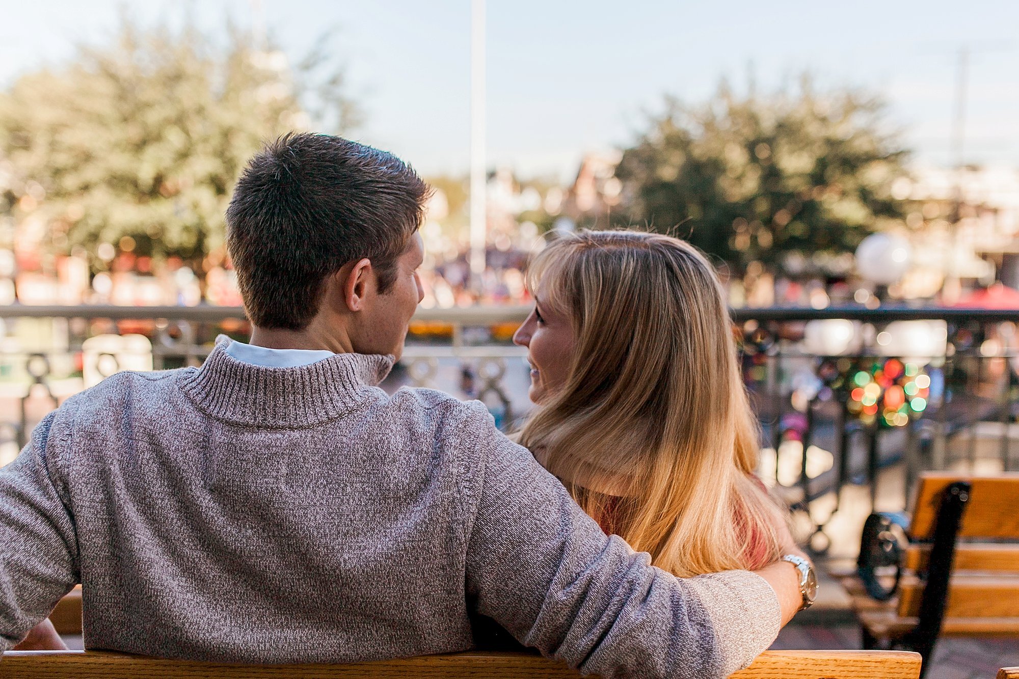  bride and groom looking at one another on a bench at the disney train station 