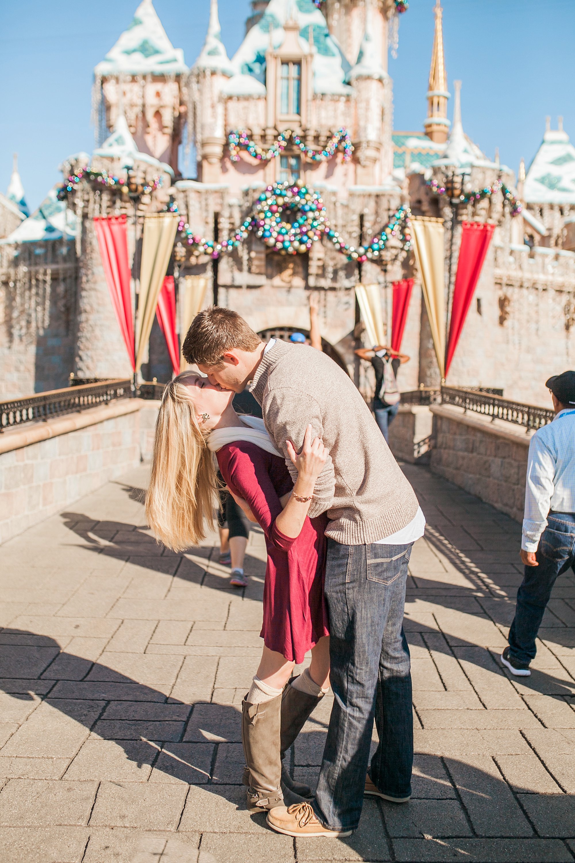  engaged couple kissing in front of magic kingdom 