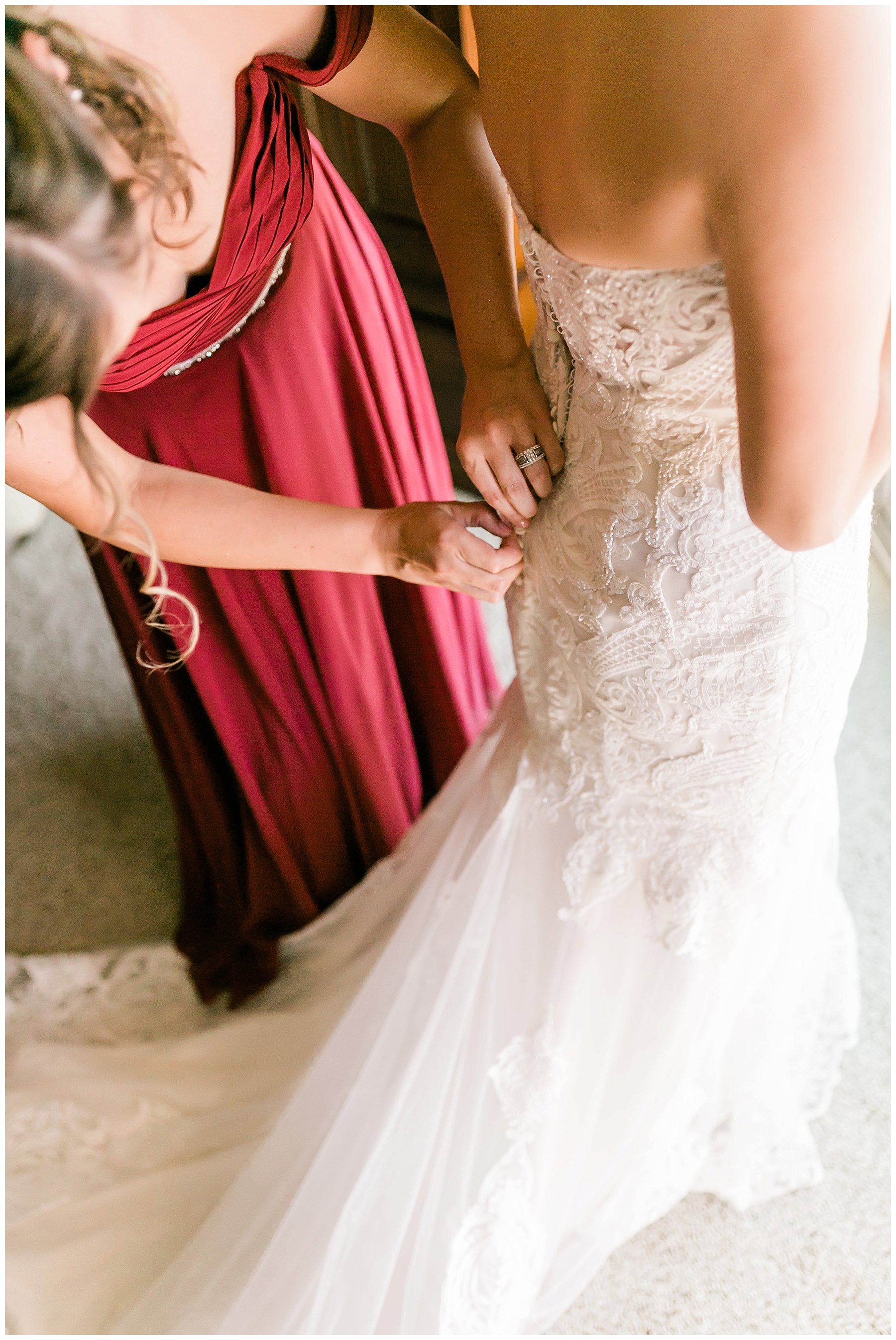  maid of honor helping bride get into her gown 