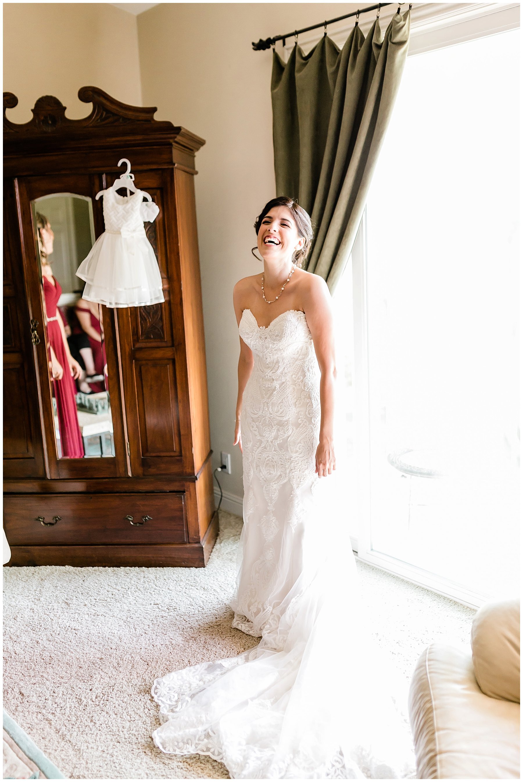  bride standing in front of the window in her gown 