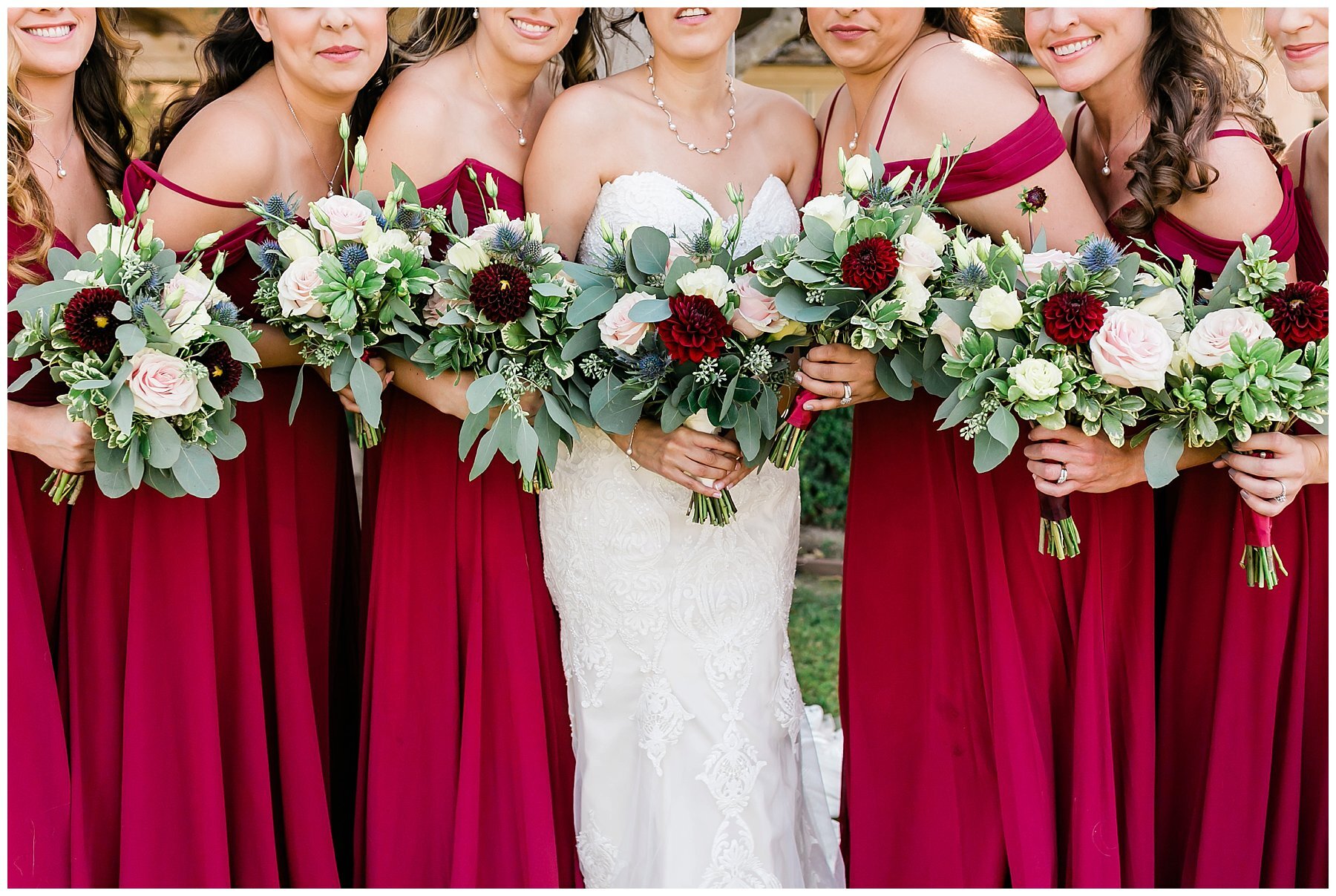  bride in her gown with her bridesmaids holding bouquets 